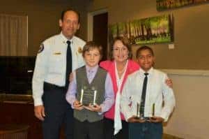 Orange County Mayor Teresa Jacobs and Orange County Fire Chief Otto Drozd honor Isiah Francis and Jeremiah Grimes with the Mayor’s Hero Award and an Honorary Firefighter plaque at a recent Board of County Commissioners meeting. 
