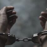 Image of a dark-skinned person in handcuffs