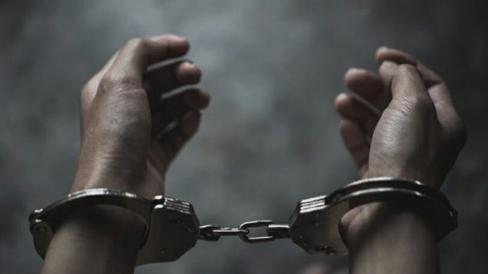 Image of a dark-skinned person in handcuffs