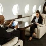 Photo of two people seated in private plane