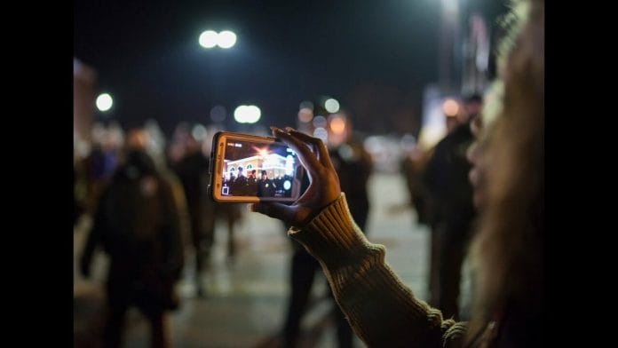 filmingpolice photo of woman filming police with her cell phone