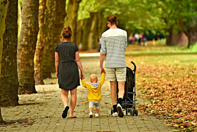 family in park Image of parents and child walking in the park