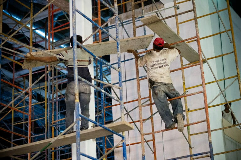 Photo of two workers on construction site doing dangerous work