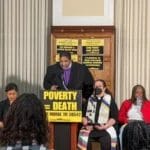 Photo of Dr. William Barber speaking at podium