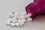 a pill bottle on the table with pills spilling out